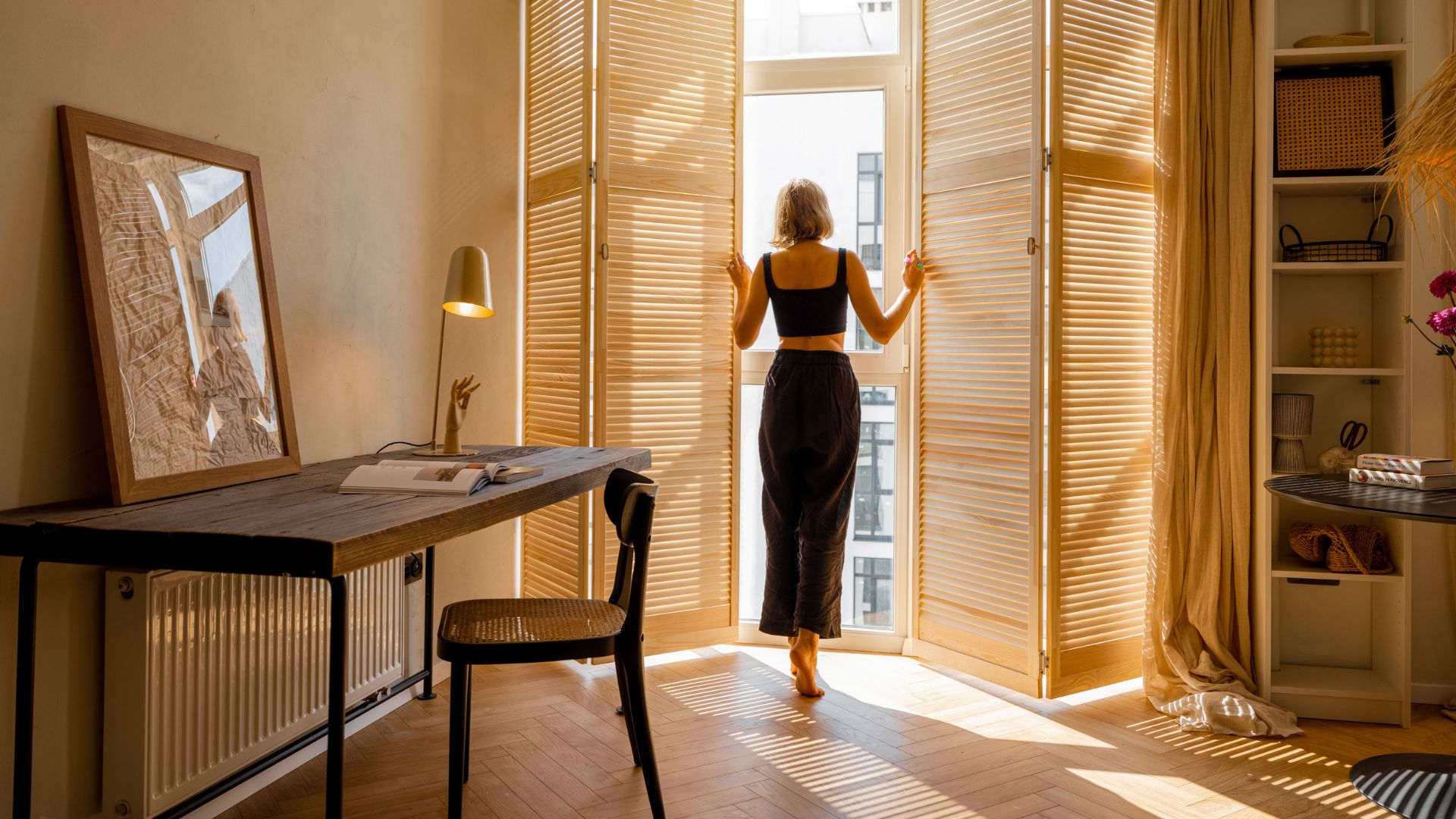 A woman standing in a room looking out a window