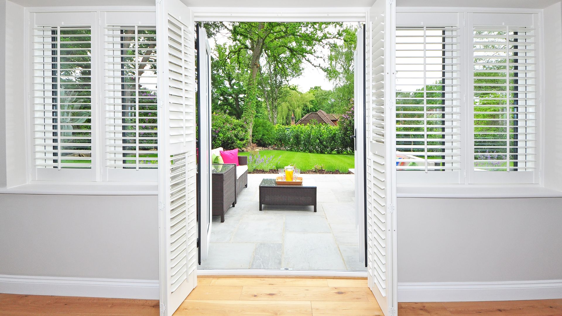 A living room with white shutters and a coffee table